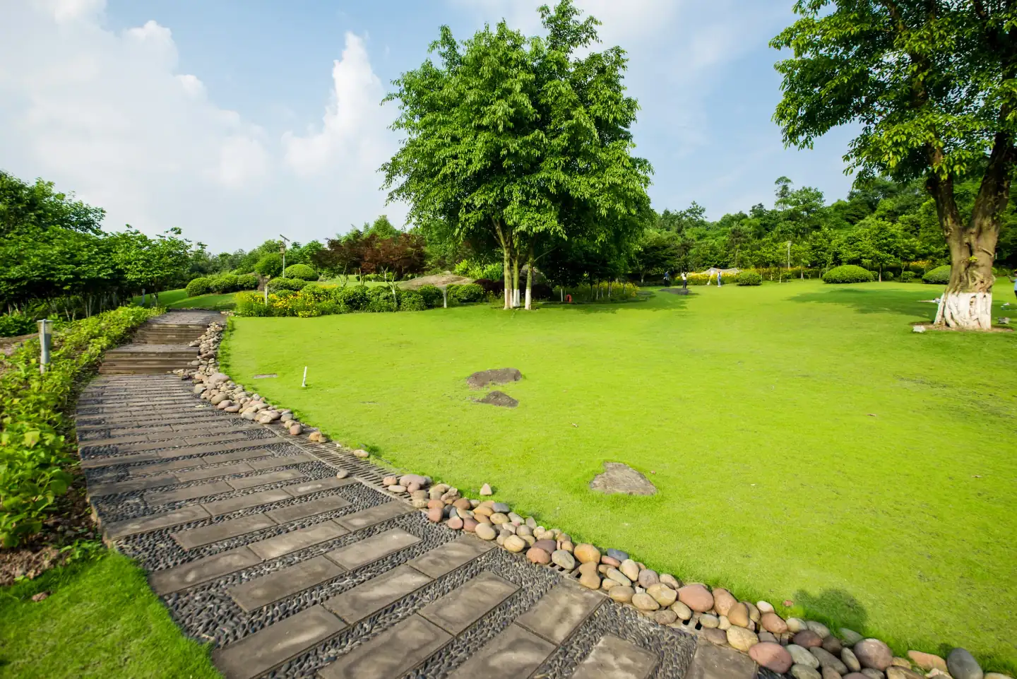 Stone garden path through a freshly maintained landscaped lawn